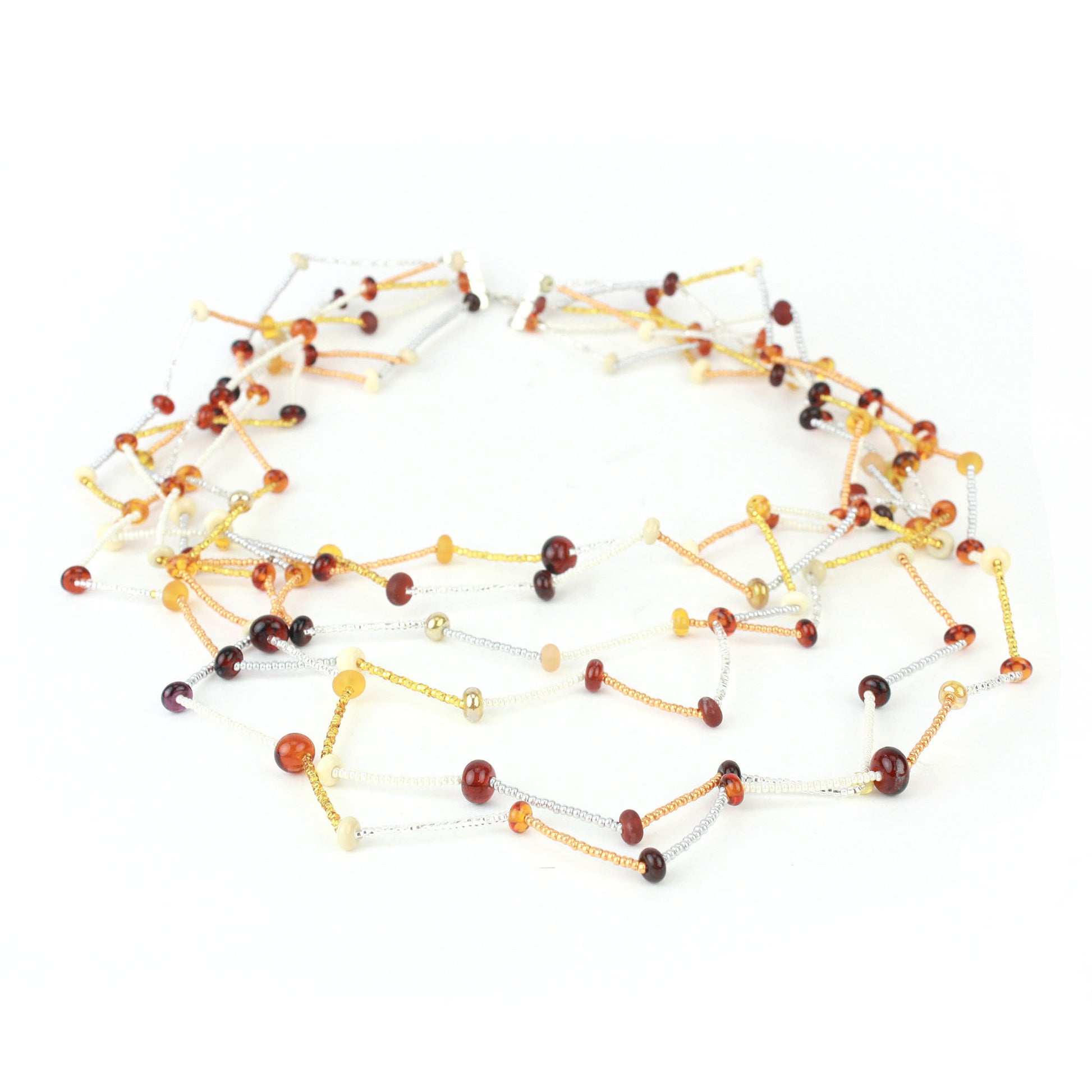 The Fiesta Necklace in amber, ivory and gold. Handcrafted six-strand necklace in amber, ivory, and gold glass beads with handmade lampwork accents and a zig-zag drape.