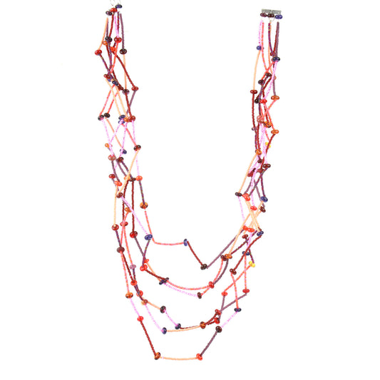 Fiesta Necklace in reds, oranges, pinks and plums. Bold six-strand necklace in red, mauve, and orange hues with handcrafted lampwork beads in a sculptural zig-zag layout.
