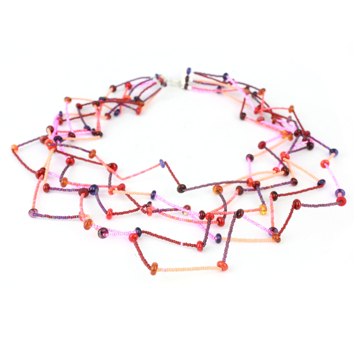 Fiesta Necklace in reds, oranges, pinks and plums. Bold six-strand necklace in red, mauve, and orange hues with handcrafted lampwork beads in a sculptural zig-zag layout.