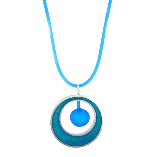 The Glory Necklace in Aqua, featuring a handcrafted pendant made from eco-resin, salvaged aluminum, and frosted blown glass, suspended on a fully adjustable silicone cord.